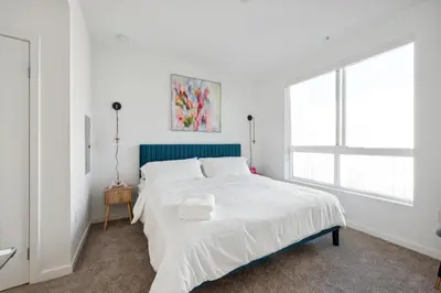 a white bedroom with a large window and a bed at Spacious 1BDR near Walk of Fame with Luxury Amenities in Los Angeles