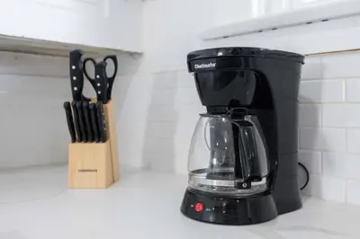 a black coffee maker on a counter next to a knife block at Charming Craftsman Near DTLA in Los Angeles