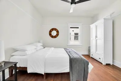 a white bedroom with a bed and a mirror at Charming Craftsman Near DTLA in Los Angeles