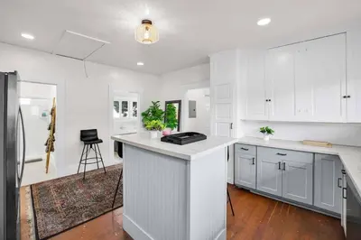 a kitchen with white cabinets and a counter top at Charming Craftsman Near DTLA in Los Angeles
