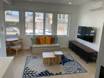 a living room with a couch and a table at Pacific Coast Suites - Oceanfront Living in Los Angeles