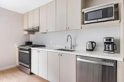 a kitchen with white cabinets and a microwave at Blueground Downtown elevator nr parks LAX-1251 in Los Angeles