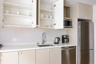 a kitchen with white cabinets and a stainless steel refrigerator at Blueground Downtown elevator nr parks LAX-1251 in Los Angeles