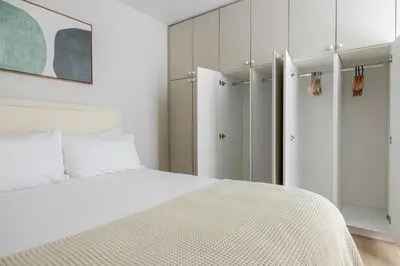 a white bedroom with a bed and a closet at Blueground Downtown elevator nr parks LAX-1252 in Los Angeles