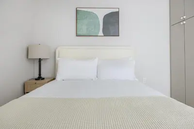 a bedroom with a white bed with a white bedspread at Blueground Downtown elevator nr parks LAX-1252 in Los Angeles