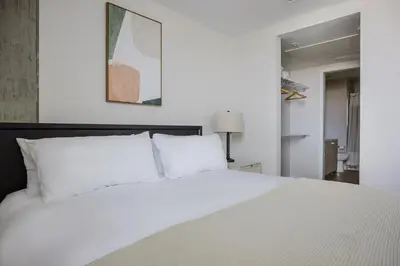 a white bed with white pillows in a bedroom at Blueground Downtown AC elevator nr parks LAX-1253 in Los Angeles