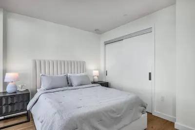 a white bedroom with a large bed and two lamps at The Sky Gem in Los Angeles