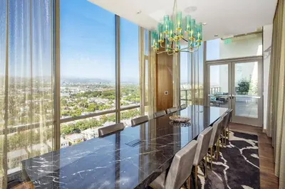 a dining room with a table and chairs and a chandelier at The Sky Gem in Los Angeles