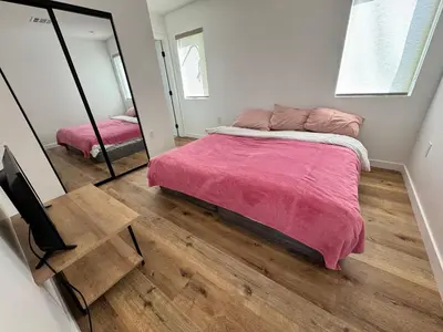 a bedroom with a large bed and a mirror at Los Angeles Central Town House in Los Angeles