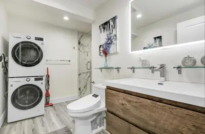 a bathroom with a washing machine and a sink at Wellness Temple LA in Tarzana