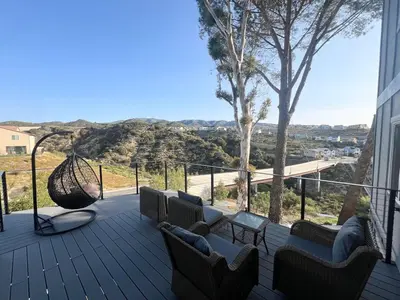 a deck with chairs and a hammock on a house at Rancho del Cielo in Twin Lakes