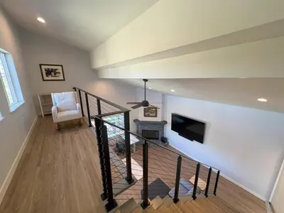 a room with a staircase with a tv and a chair at Rancho del Cielo in Twin Lakes