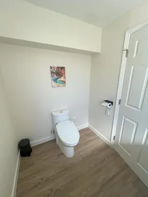 a white bathroom with a toilet and a door at Rancho del Cielo in Twin Lakes