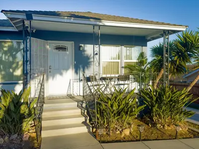 a house with a front porch with a blue door at Quaint Mid-Century Cottage by the Coast in Ventura