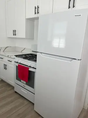 a white kitchen with a stove and a refrigerator at Sunny Franklin Place in Los Angeles