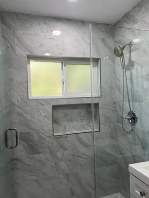 a bathroom with a glass shower with a window at Sunny Franklin Place in Los Angeles