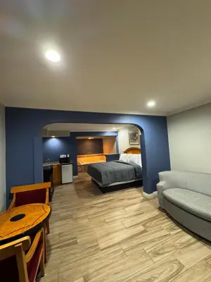 a bedroom with a bed and a couch and a table at Sunset Inn & Suites in Gardena