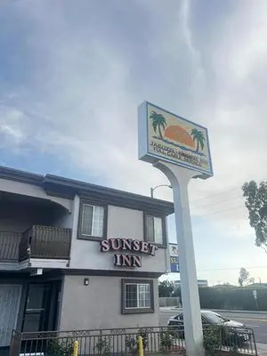 a suntrust inn sign in front of a building at Sunset Inn & Suites in Gardena