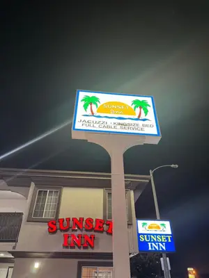 a sign for a sunset inn in front of a building at Sunset Inn & Suites in Gardena