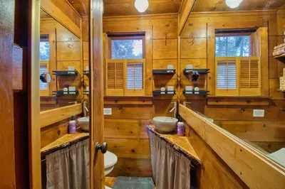 a wooden bathroom with two sinks and a toilet at Ray's Dear Cottage in Wrightwood