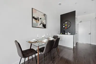 a dining room with a table and chairs and a clock at Hollywood 1bdr Comfort with Pool, Gym, Free Parking in Los Angeles
