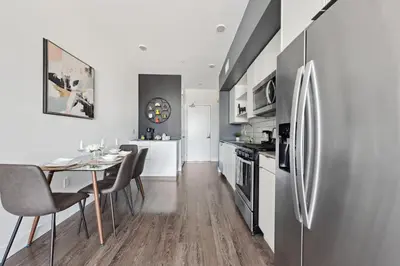a kitchen with a dining table and a refrigerator at Hollywood 1bdr Comfort with Pool, Gym, Free Parking in Los Angeles
