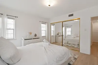 a white bedroom with a bed and a mirror at Spacious 4BR House with Large Yard and Parking Beverly Hills Adj in Los Angeles