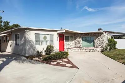 a house with a red door and a driveway at Central Modern All-In-One Home in Lakewood