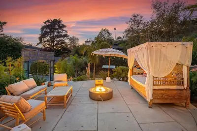a backyard patio with a couch and an umbrella at Seaside and Newly Renovated in Summerland