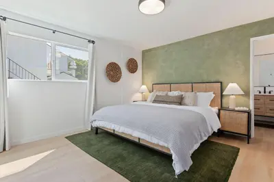 a bedroom with a bed and a large window at Private Garden and Family Friendly in Summerland