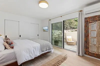 a bedroom with a bed and a sliding glass door at Jasmine Hideaway and Newly Renovated in Summerland