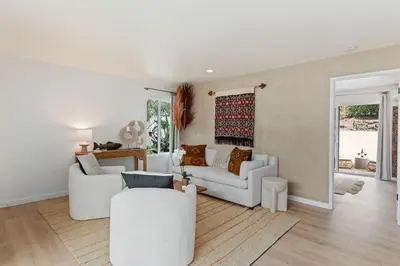 a living room with two white couches and a table at Jasmine Hideaway and Newly Renovated in Summerland