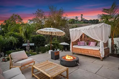 a backyard patio with a bed and a fire pit at Jasmine Hideaway and Newly Renovated in Summerland