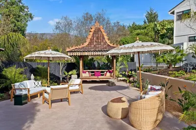 a patio with a gazebo and chairs and umbrellas at Jasmine Hideaway and Newly Renovated in Summerland