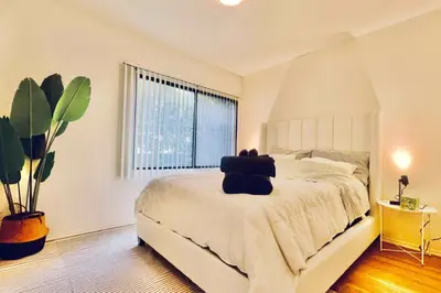 a bedroom with a white bed with a large window at Serenity Retreat in Santa Monica in Los Angeles