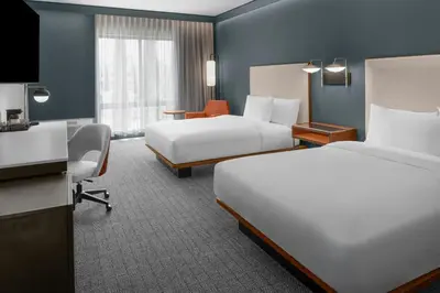 a hotel room with two beds and a desk at Courtyard by Marriott San Bernardino Loma Linda in Loma Linda