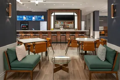 a restaurant with tables and chairs and a bar at Courtyard by Marriott San Bernardino Loma Linda in Loma Linda
