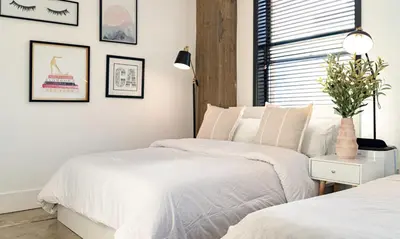a bedroom with two beds and a window at Stylish loft 2 queens & 2 sofas in Los Angeles