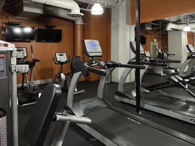 a gym with several tread machines in a room at Stylish loft 2 queens & 2 sofas in Los Angeles