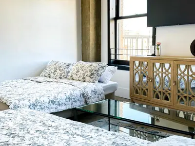 a living room with a couch and a glass table at Stylish loft 2 queens & 2 sofas in Los Angeles