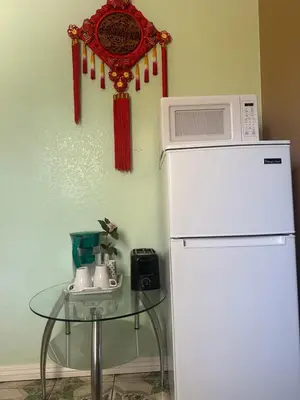 a microwave on top of a refrigerator next to a table at Nice Room Near Citrus College in Glendora
