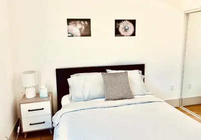 a bedroom with a bed and two pictures on the wall at Newly Gated Stylish Steps to Hollywood 2B2B in North Sherman Way