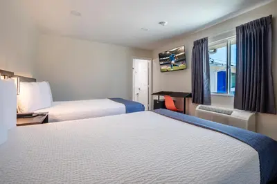 a hotel room with two beds and a window at La Casita Inn in Wilmington
