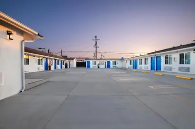 an empty parking lot with blue and white buildings at La Casita Inn in Wilmington