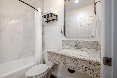 a bathroom with a sink and a toilet and a mirror at La Casita Inn in Wilmington