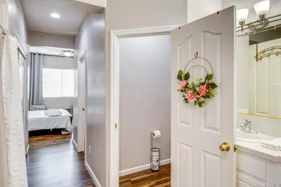 a bathroom with a white door with a flower wreath at 8 Mi to Beach Park Bakersfield Gem with Yard! in Bakersfield