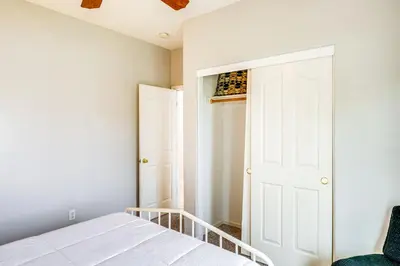 a bedroom with a white bed and a closet at 8 Mi to Beach Park Bakersfield Gem with Yard! in Bakersfield
