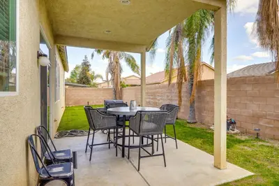 a patio with a table and chairs on it at 8 Mi to Beach Park Bakersfield Gem with Yard! in Bakersfield