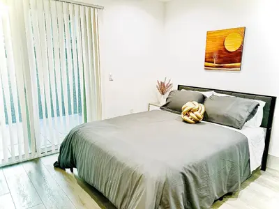 a bedroom with a large bed with a large window at Newly Built Stylish Modern 2B In LA in North Sherman Way
