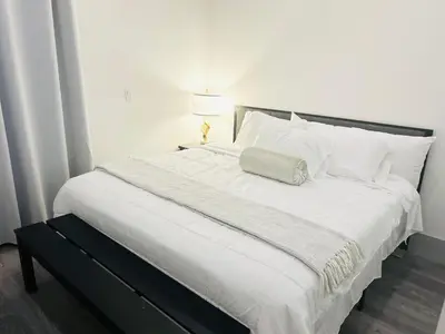 a white bed with a pillow on top of it at Newly Built Stylish Modern 2B In LA in North Sherman Way